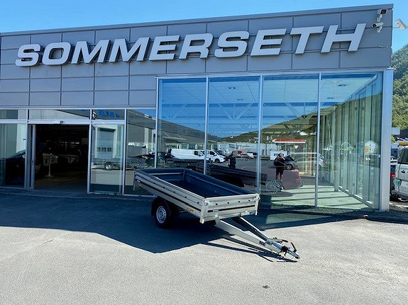 Tilhenger foran bilforhandler Sommerseth i solfylt vær.