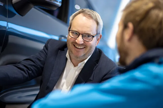 Mann i samtale ved bilutstilling