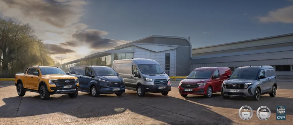 Ford sin range av varebiler parkert foran et bygg.